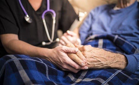 caregiver holding patient's hands