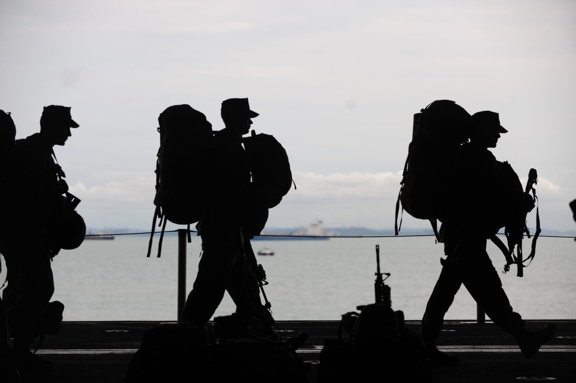 three veterans with large backpacks