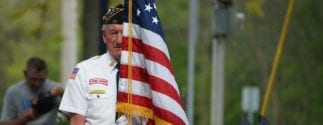 Older veteran holding an american flag