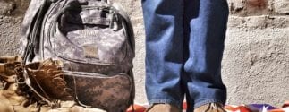 Veteran's Boots and Backpack Next to Legs