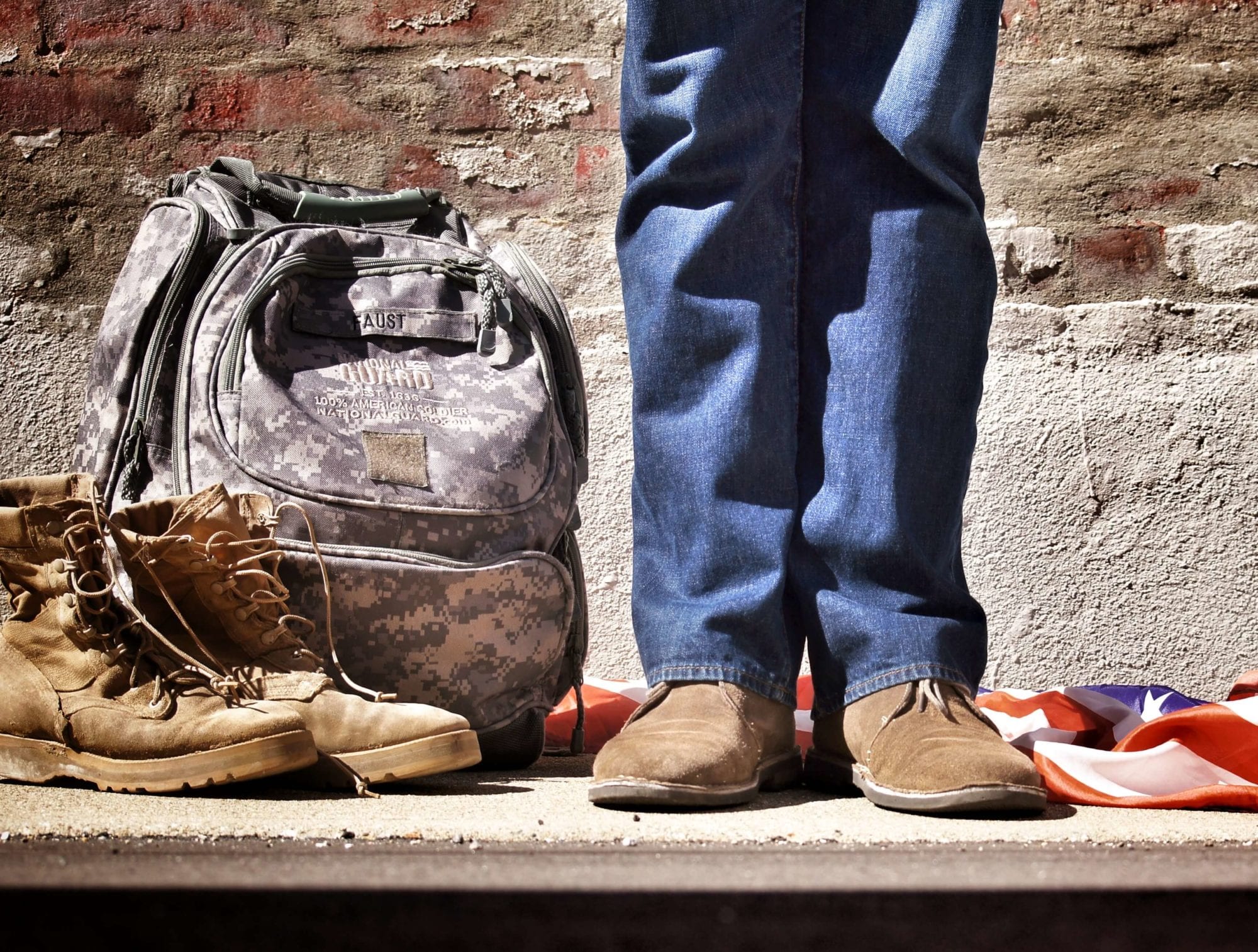 Veteran's Boots and Backpack Next to Legs