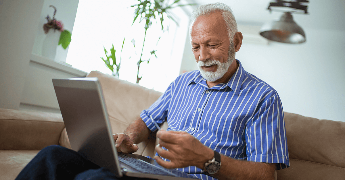 elderly man looking at a laptop