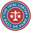 The Trial Lawyer Hall of Fame Logo. Red and blue circle with white scales in the center.