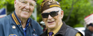 Two older veterans stand next to one another