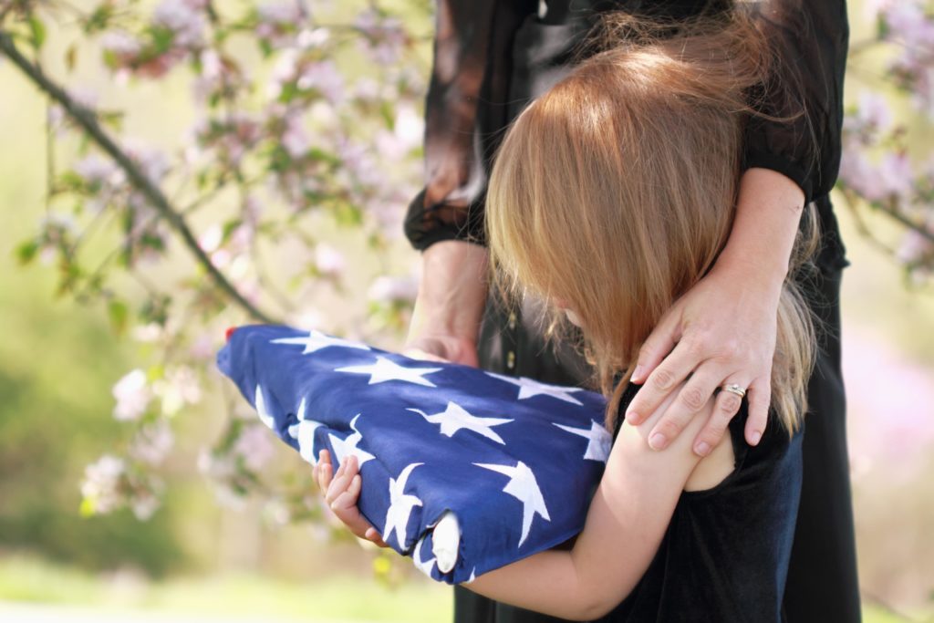 family holding veterans flag