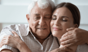 An older man hugs his daughter