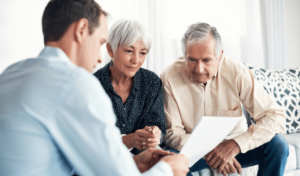 An older couple reviews documents with a younger male attorney