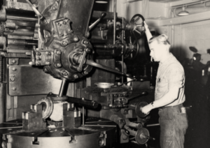 a black and white photo of a Navy sailor working on machinery