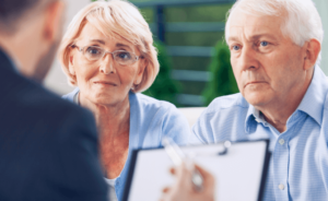 an elderly couple talking to an attorney