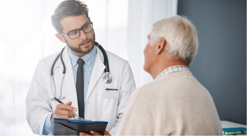 A doctor speaks with an older male patient