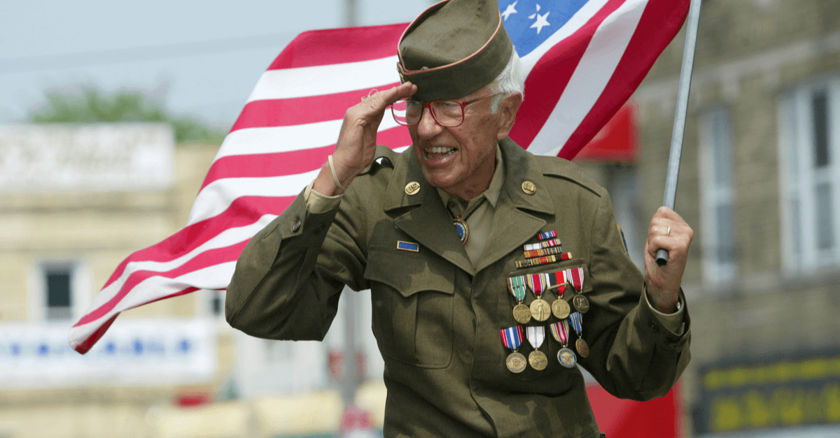 A veteran holds an American flag in a parade