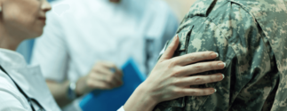 a doctor puts her hand on a veteran's shoulder