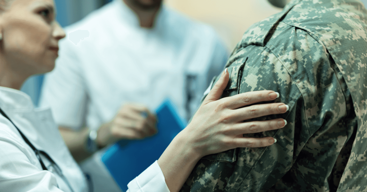 a doctor puts her hand on a veteran's shoulder