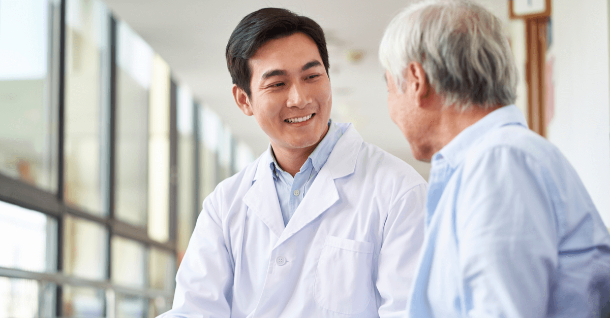 A doctor sits with an older patient