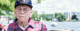 An older male veteran sits outside.