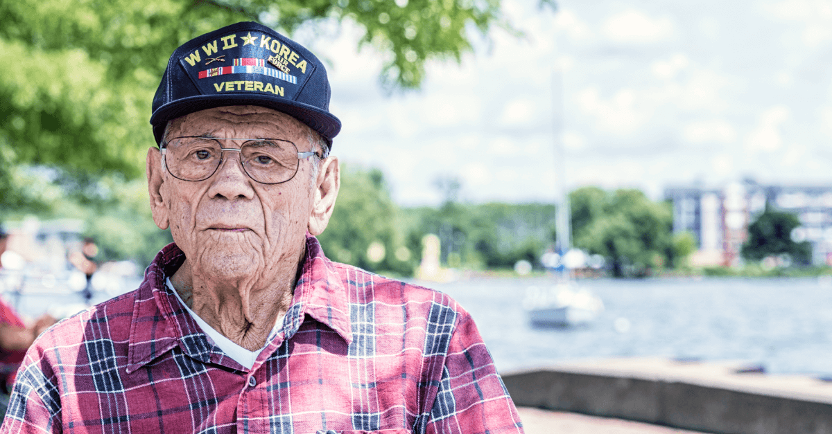 An older male veteran sits outside.