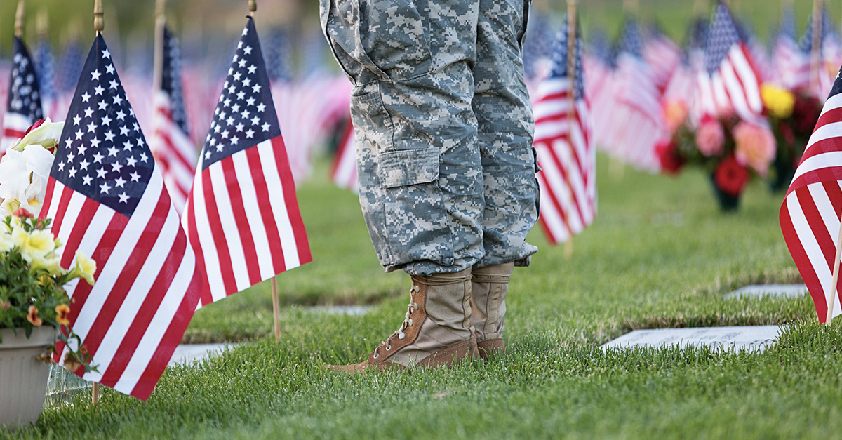 Veteran at cemetery decorated with American flags