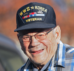 A man wearing a World War II and Korean War veteran hat