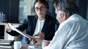 A woman looks over documents with an older man