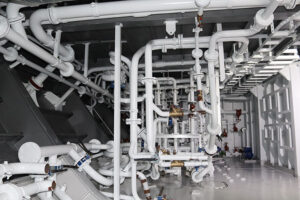 A series of white pipes running through a Navy ship