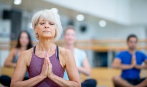 older woman doing yoga in a class
