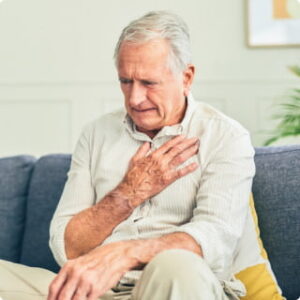 An older man clutches his chest in discomfort
