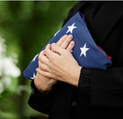 hands holding a folded American flag