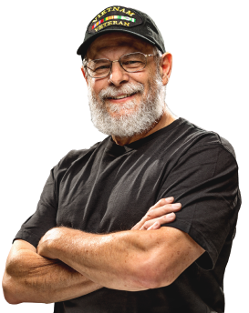An older man with a beard wearing a Vietnam veterans hat