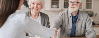An older couple meets with a younger person at a table.