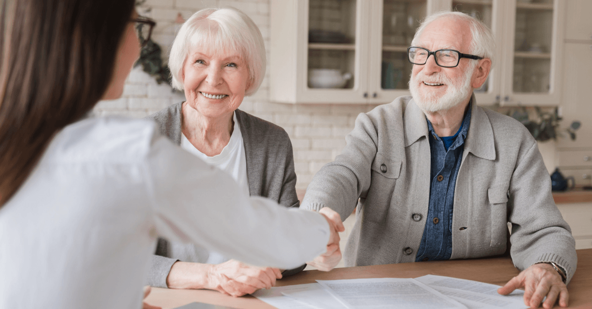 An older couple meets with a younger person at a table.